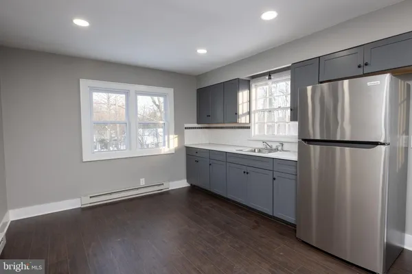 a kitchen with granite countertop stainless steel appliances a refrigerator sink and wooden floor