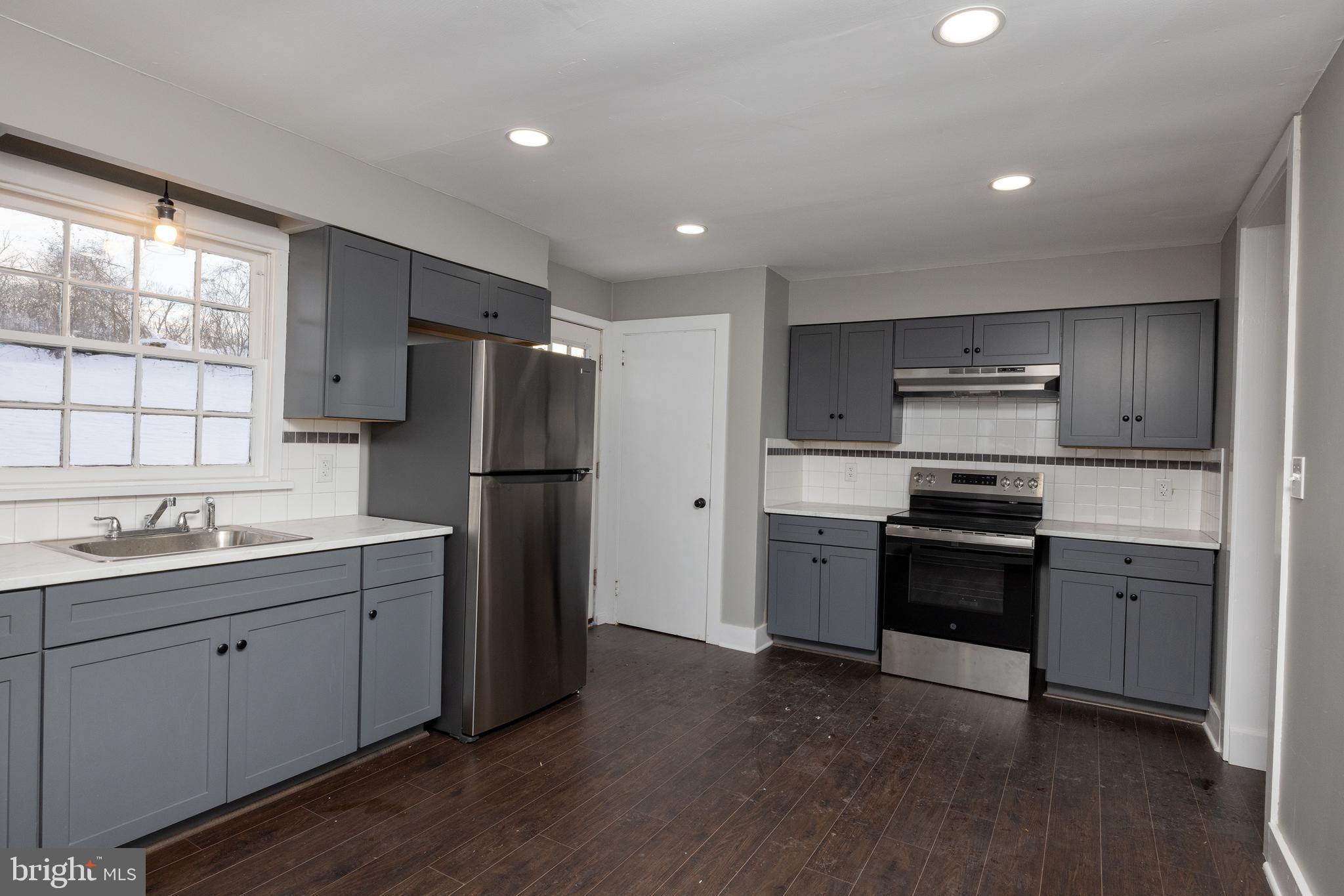6192 Lower York Road, Unit B New Hope, PA 18938 - Photo 3 of 11 a kitchen with stainless steel appliances granite countertop a refrigerator a sink dishwasher a stove and white cabinets with wooden floor