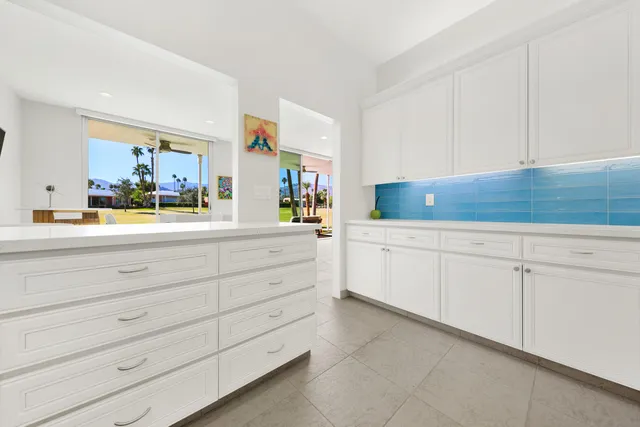 a kitchen with white cabinets and a sink