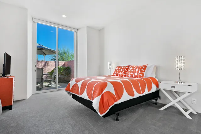 a bedroom with a bed and large window