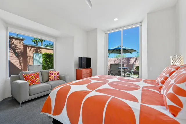 a bedroom with a bed chair and a desk