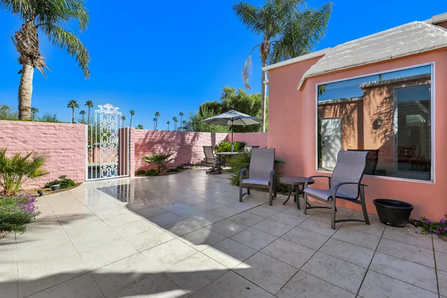 a view of a patio with a table and chairs under an umbrella