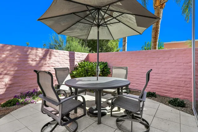 a patio with a table and chairs under an umbrella