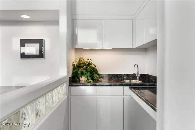 a kitchen with granite countertop a sink and cabinets