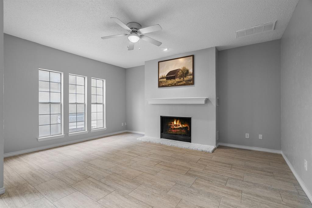 5310 Keller Springs Road, Unit 626 Dallas, TX 75248 - Photo 1 of 13 wooden floor fireplace and windows in an empty room
