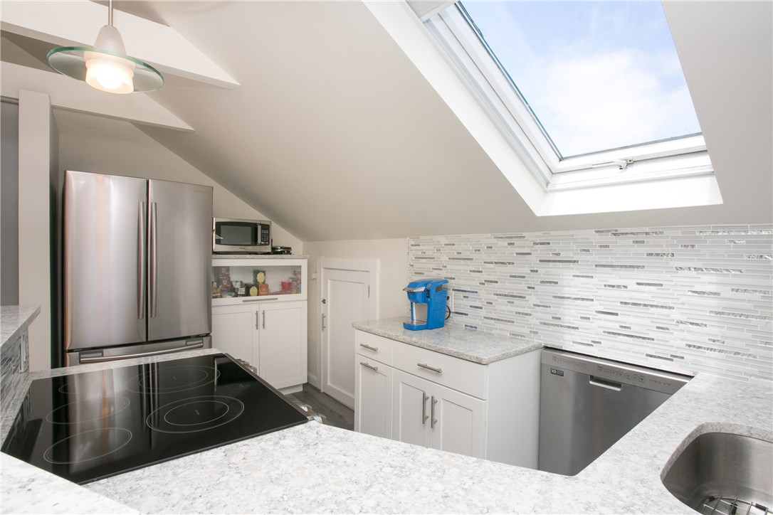 42 Kay Street, Unit 5 Newport, RI 02840 - Photo 18 of 34 The cabinet next to the refrigerator is built in and has a quartz top.Plenty of storage in the closet to the right, which is open as far as the dishwasher under the eaves.