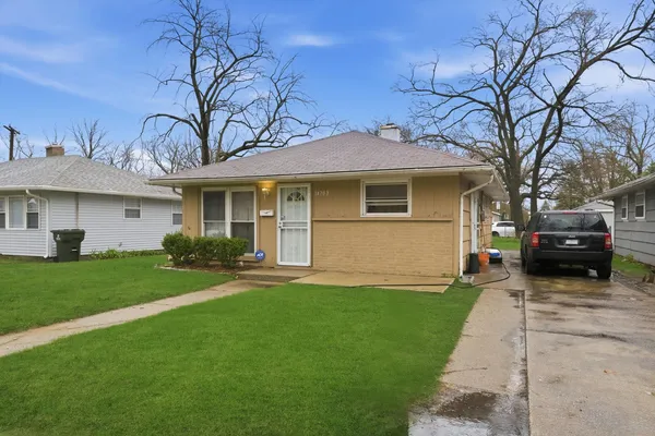 a front view of a house with a garden and yard