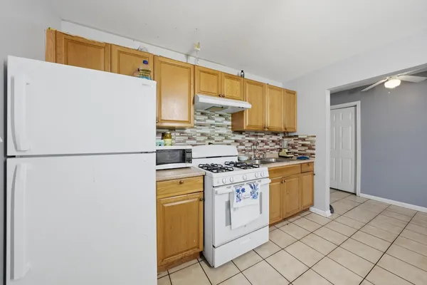 a kitchen with stainless steel appliances granite countertop a refrigerator sink stove and white cabinets