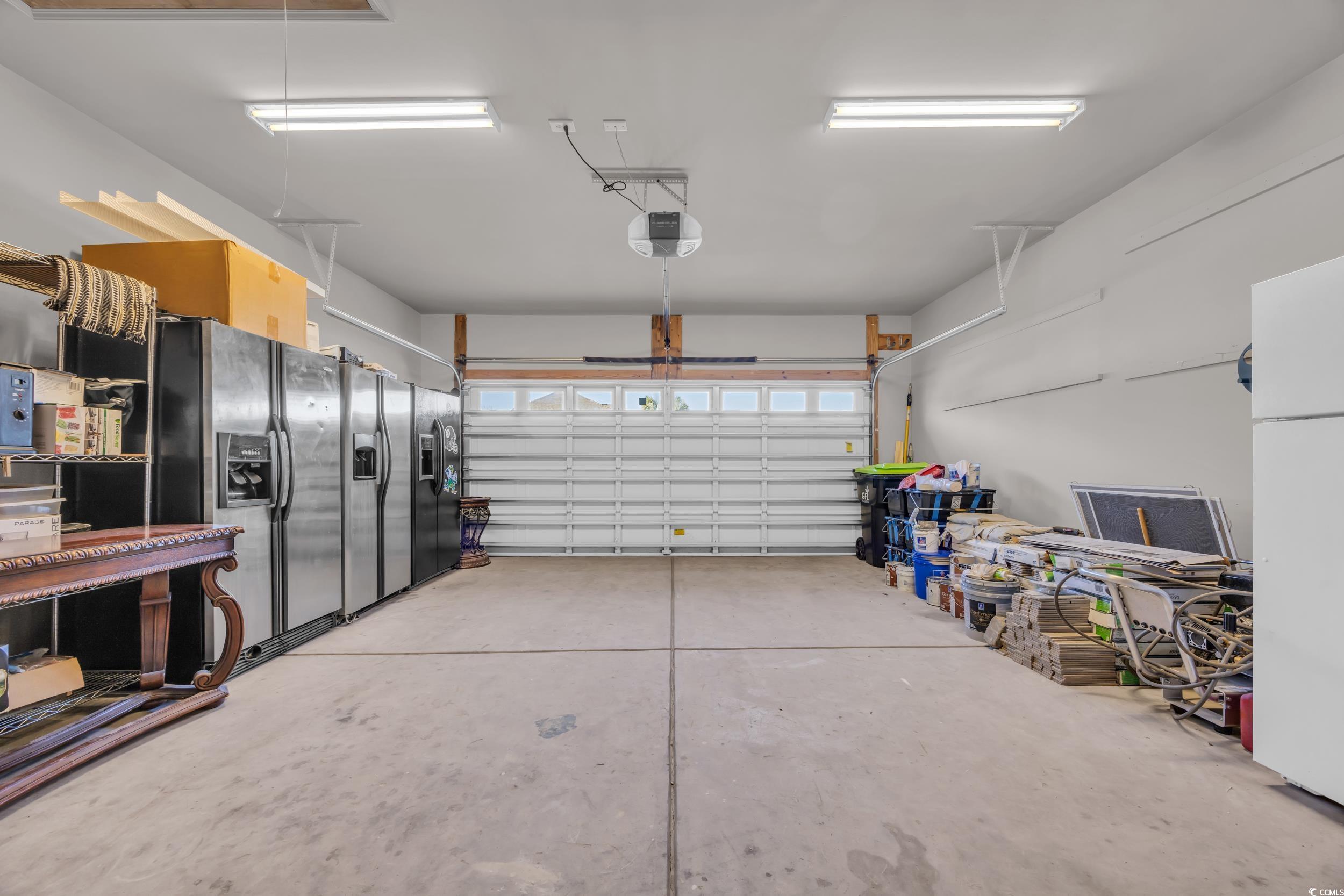 2385 Windmill Way Myrtle Beach, SC 29579 - Photo 34 of 39 Garage with a garage door opener, black fridge wit