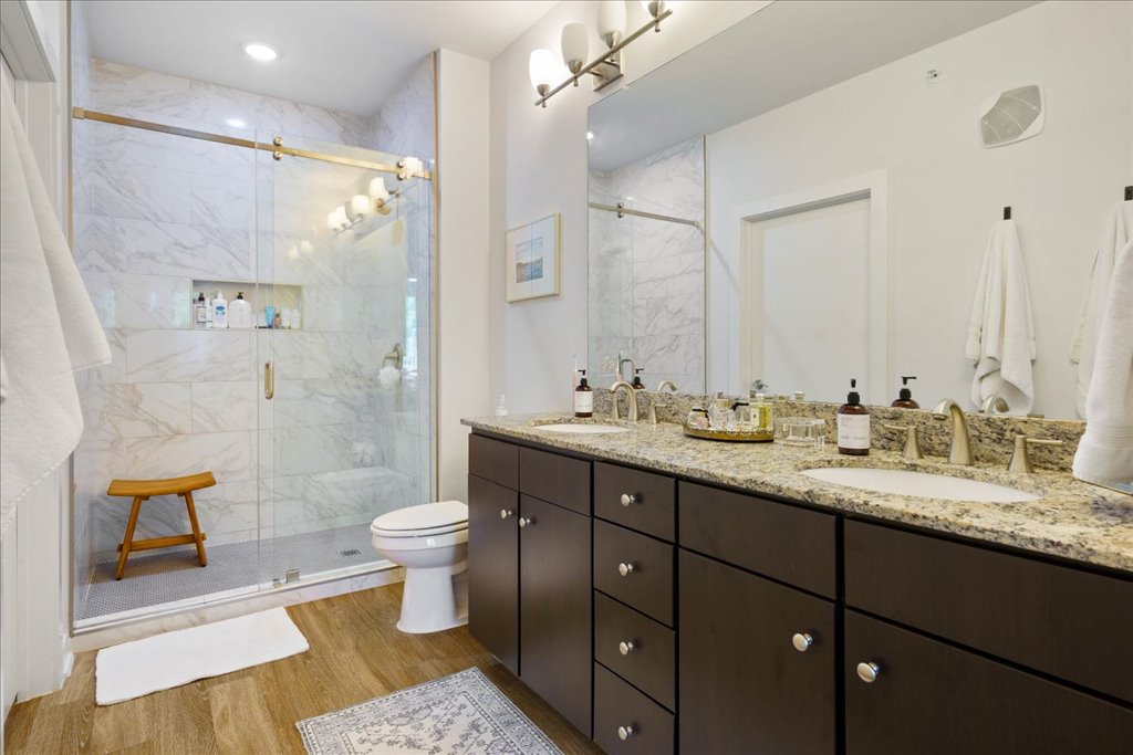 1900 Barton Springs Road, Unit 4029 Austin, TX 78704 - Photo 5 of 21 A spacious vanity with dual sinks anchors this modern bathroom featuring a tiled walk-in shower.