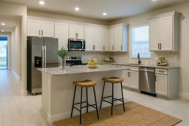 a kitchen with a sink a microwave a refrigerator and cabinets
