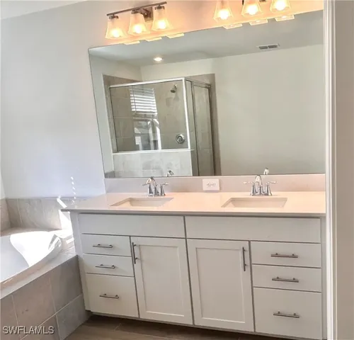 a bathroom with a granite countertop sink double and mirror