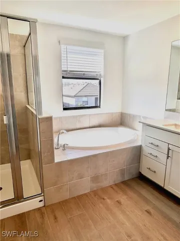 a bathroom with a tub a sink and a mirror