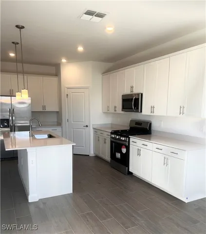 a kitchen with kitchen island a sink stove and refrigerator