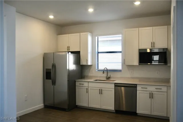 a kitchen with white cabinets and stainless steel appliances
