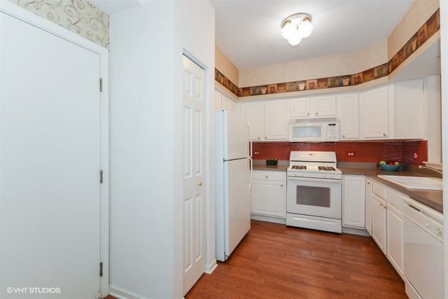 898 Riding Lane, Unit 898 St. Charles, IL 60174 - Photo 2 of 10 a kitchen with white cabinets and white appliances