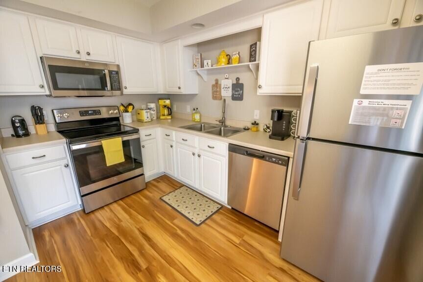 535 Orchard Valley Way Sevierville, TN 37862 - Photo 8 of 26 a kitchen with sink a microwave a refrigerator and cabinets