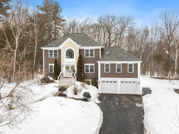 a front view of a house with a yard covered in snow