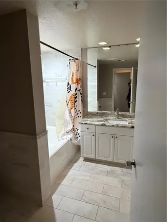 a bathroom with a sink mirror and a bathtub