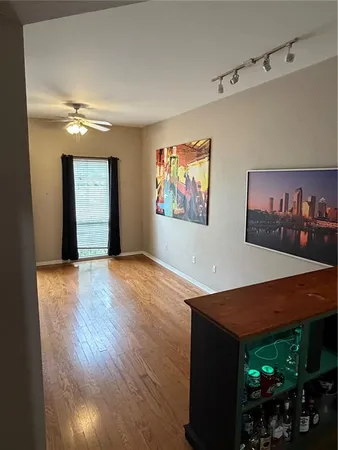 a view of an empty room with painting on the wall and window