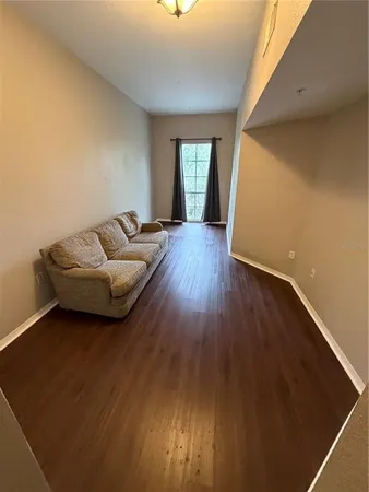 a living room with furniture and a hard wood floor