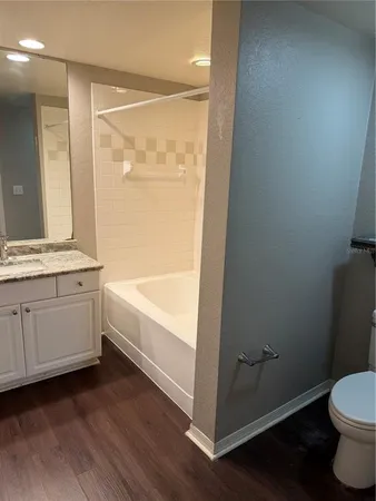 a bathroom with a granite countertop sink toilet and bathtub
