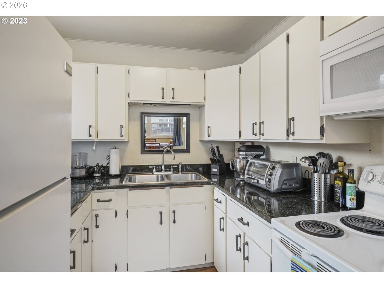 830 South 7th Street Cottage Grove, OR 97424 - Photo 24 of 33 a kitchen with kitchen island granite countertop a sink a stove and cabinets