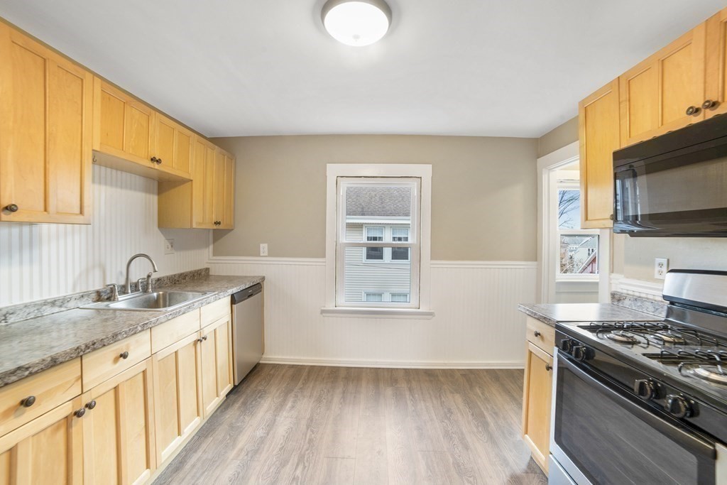 22 Ridgeway Street, Unit 2 Quincy, MA 02170 - Photo 4 of 15 a kitchen with a sink stove top oven and cabinets