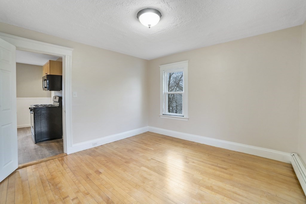 22 Ridgeway Street, Unit 2 Quincy, MA 02170 - Photo 7 of 15 a view of empty room with wooden floor and kitchen view