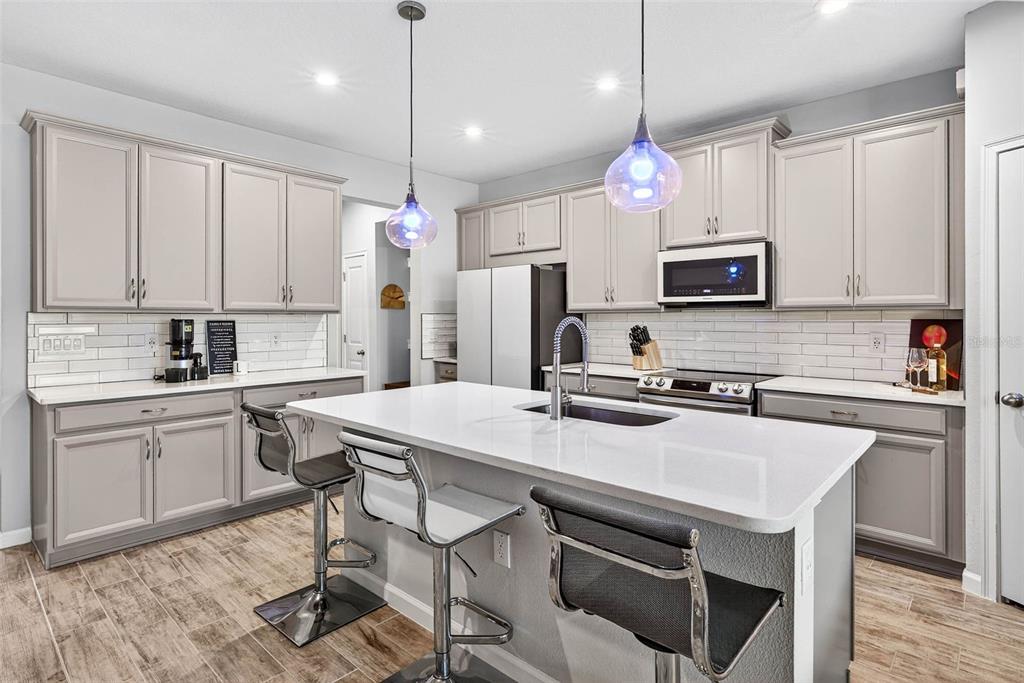 25993 Woven Wicker Bend Lutz, FL 33559 - Photo 2 of 45 a kitchen with kitchen island a sink stove and microwave