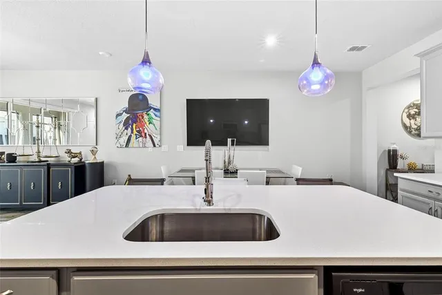 a kitchen with a sink and a chandelier
