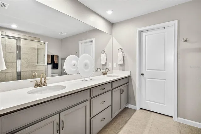a bathroom with double vanity sinks and a mirror