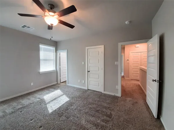 an empty room with fan and windows