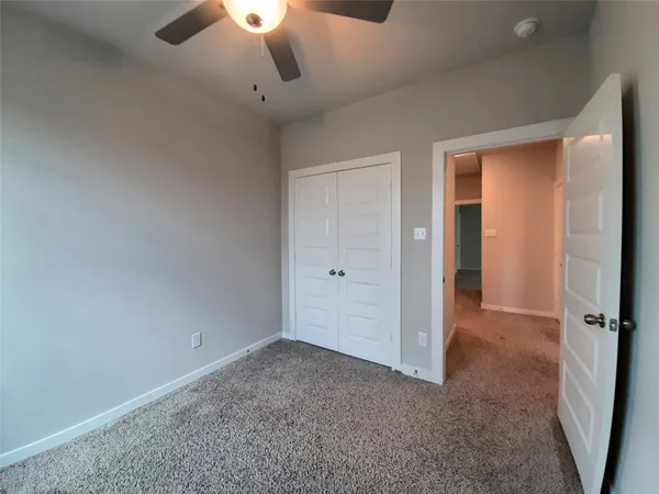 a view of a livingroom with a ceiling fan and window