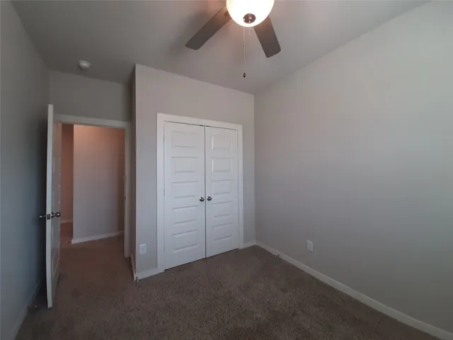an empty room with a empty space and a ceiling fan