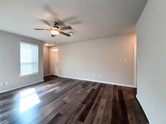 wooden floor in an empty room with a window