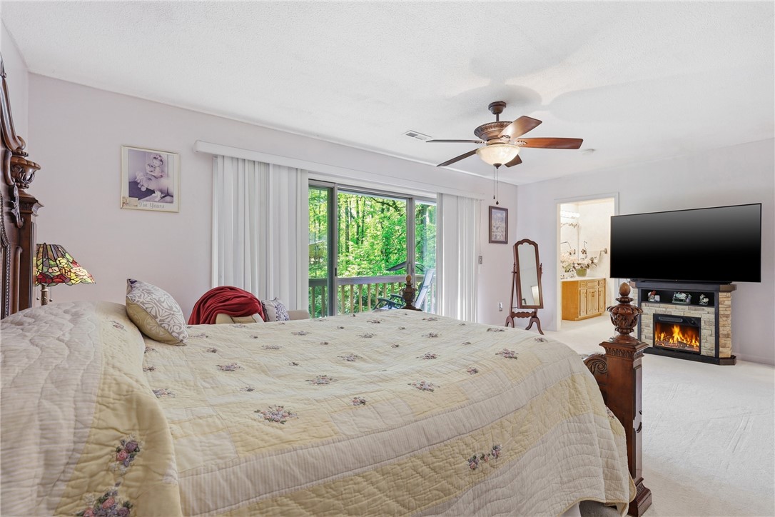 110 Shaftsbury Road Clemson, SC 29631 - Photo 14 of 38 This spacious bedroom offers a tranquil retreat with outdoor access and a cozy fireplace.