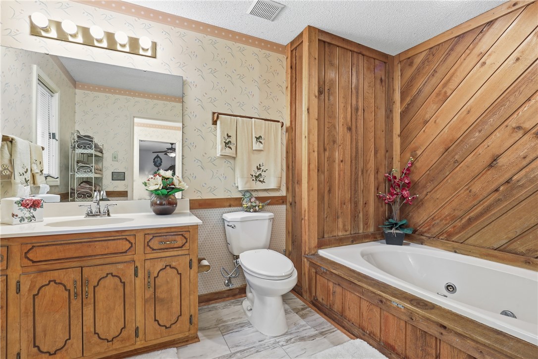 110 Shaftsbury Road Clemson, SC 29631 - Photo 16 of 38 This cozy bathroom features a vanity, toilet, and a built-in tub with charming wood paneling.