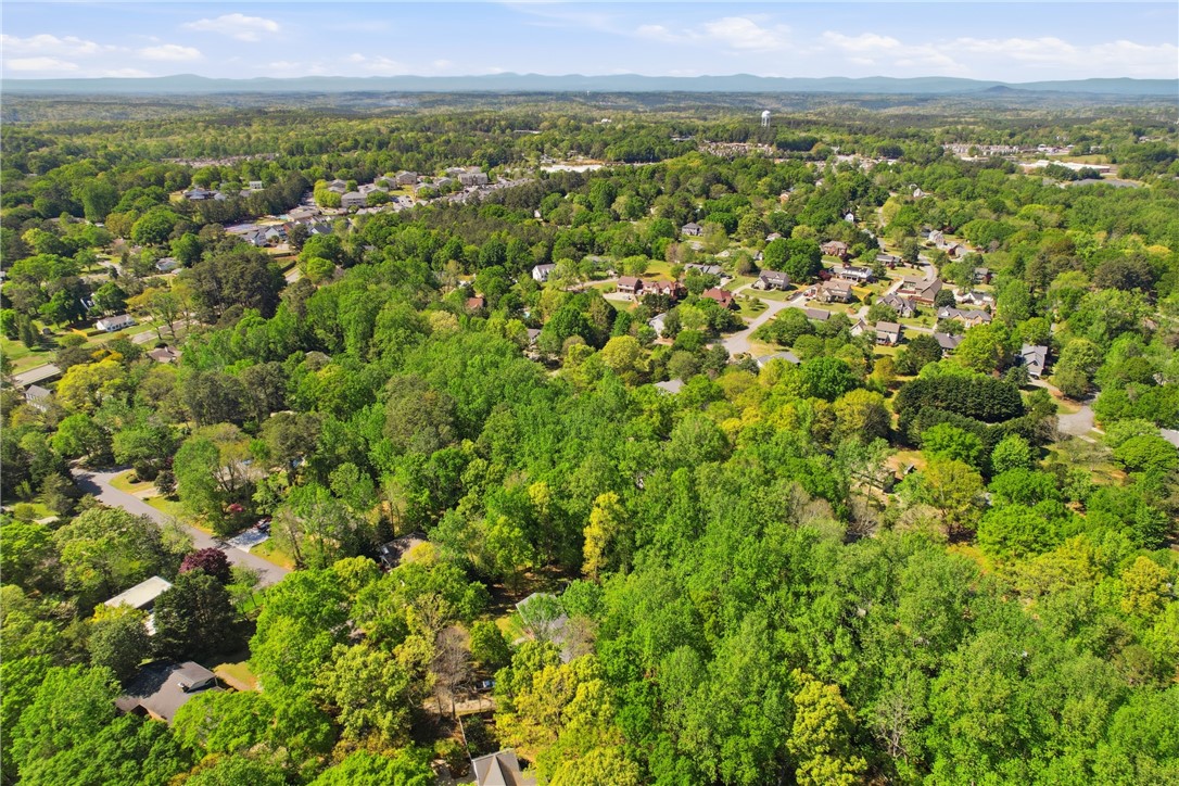 110 Shaftsbury Road Clemson, SC 29631 - Photo 34 of 38 An aerial perspective reveals a verdant neighborhood nestled within lush woodlands and a scenic mountain backdrop.