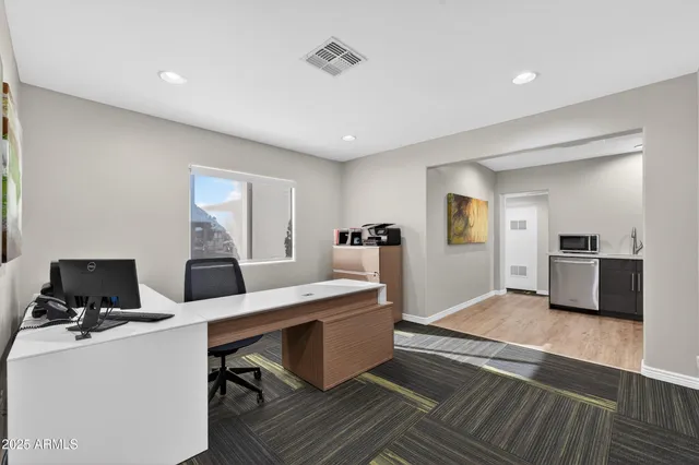 a view of a workspace with furniture and a window