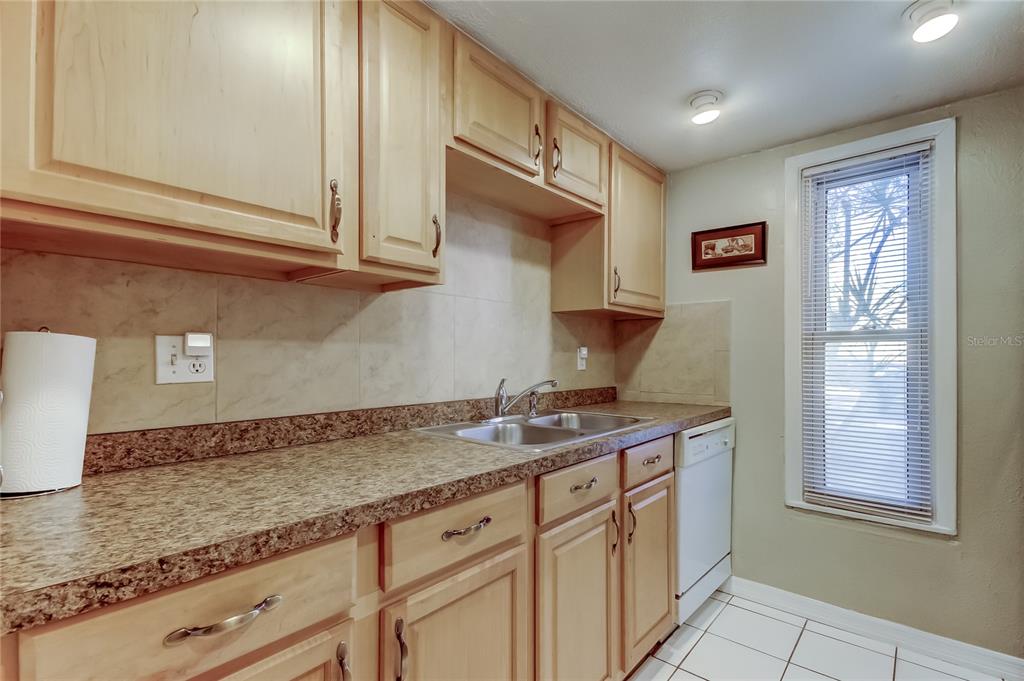 3650 41st Way South, Unit A St. Petersburg, FL 33711 - Photo 11 of 35 a kitchen with granite countertop stainless steel appliances white cabinets and a window