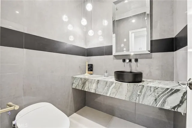 a kitchen with a sink a toilet and a mirror