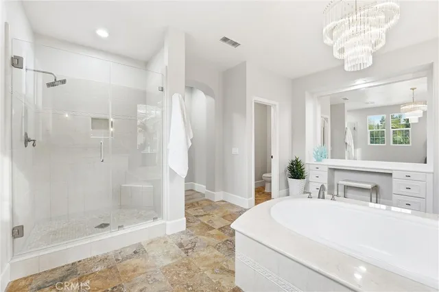a spacious bathroom with a tub shower and mirror