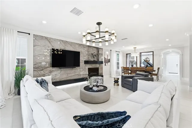 a living room with furniture a flat screen tv and kitchen view