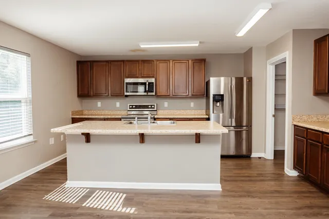 a kitchen with stainless steel appliances a refrigerator a stove a sink and a microwave