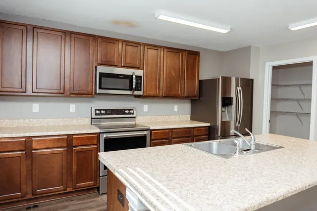a kitchen with stainless steel appliances granite countertop a stove microwave and refrigerator