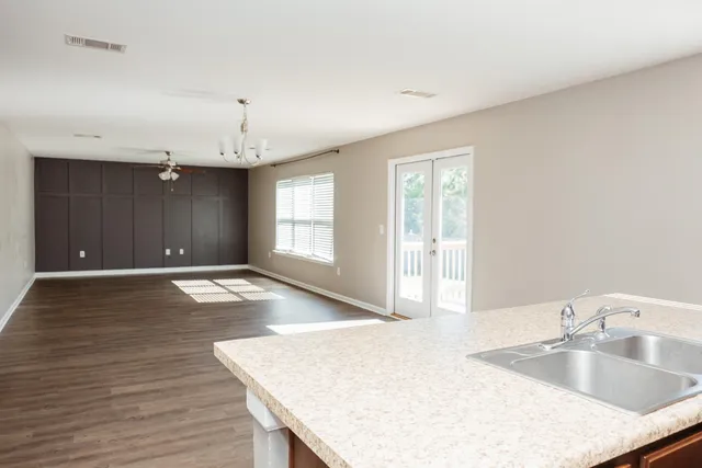a view of kitchen island a sink wooden floor and living room