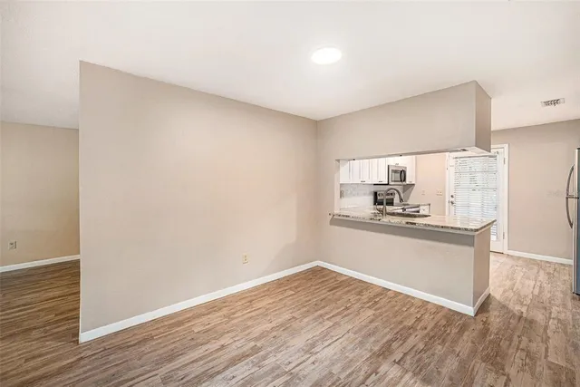 a kitchen with granite countertop white cabinets and wooden floor