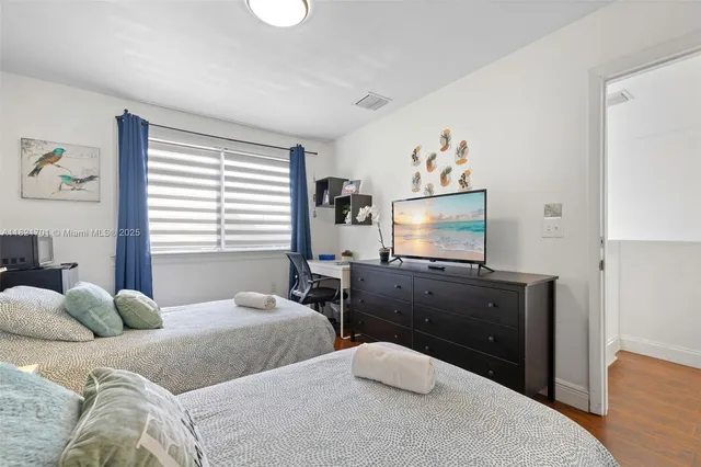 a bedroom with two beds and a desk