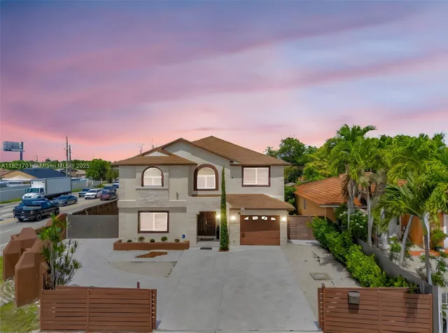 a front view of a house with a garden and a car parked
